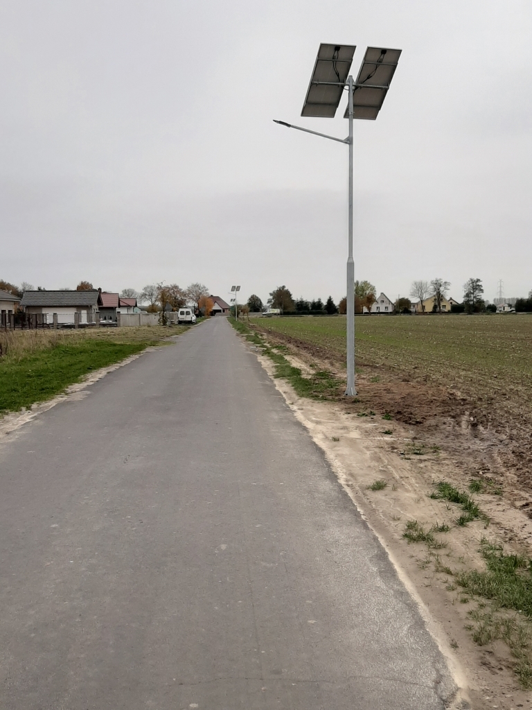 Zdjęcie przedstawia latarnię solarną umieszczoną przy drodze